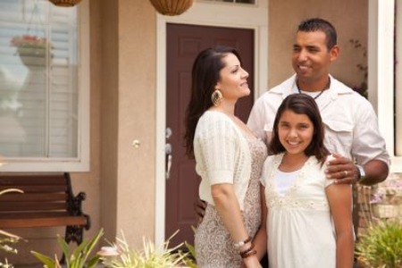 Hispanic family in front of their house